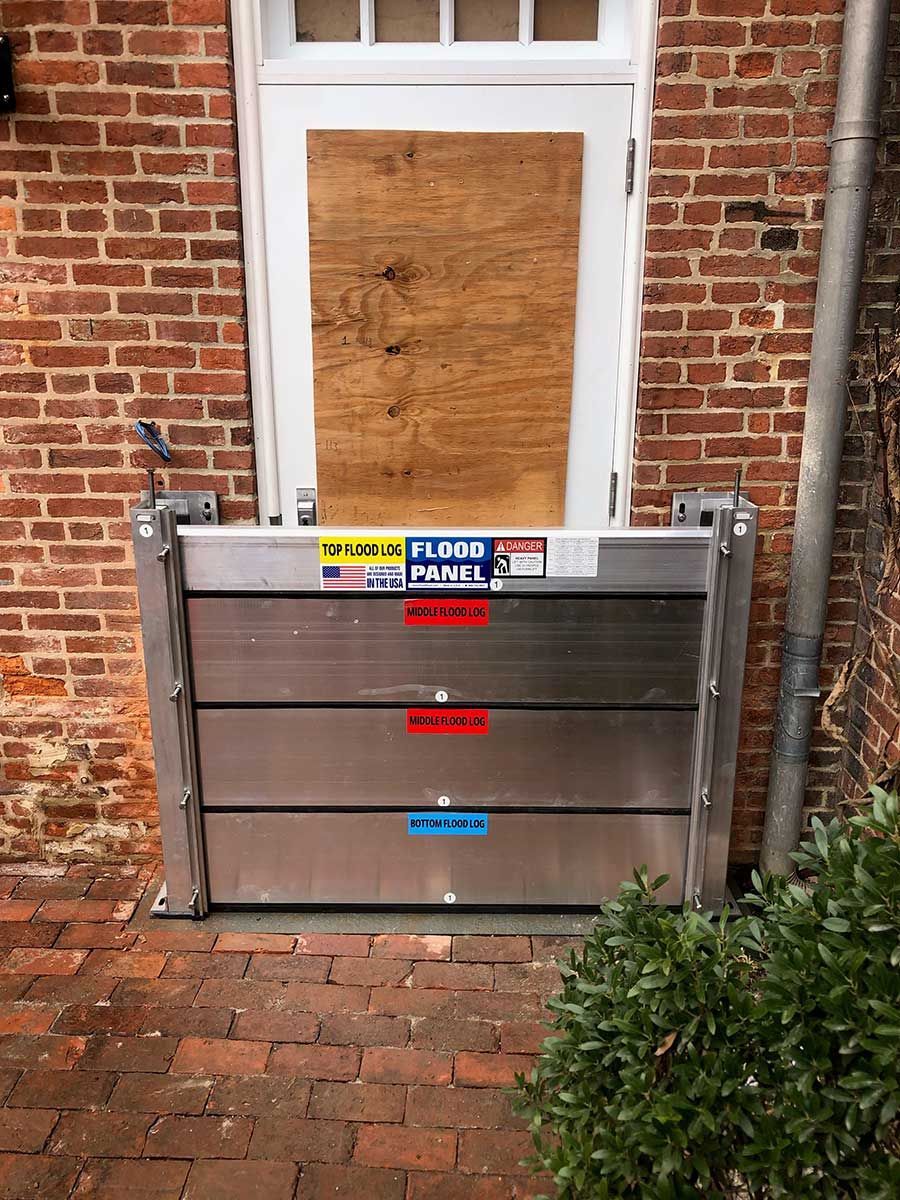 A flood barrier is sitting in front of a brick building.
