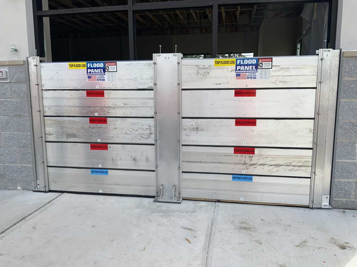 A pair of aluminum flood barriers on a sidewalk