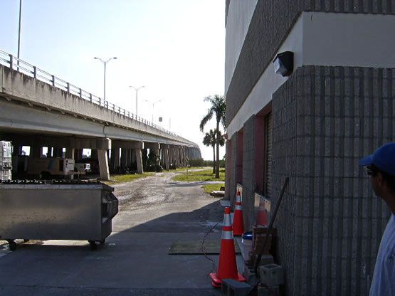 A man standing in front of a building with a truck in the background
