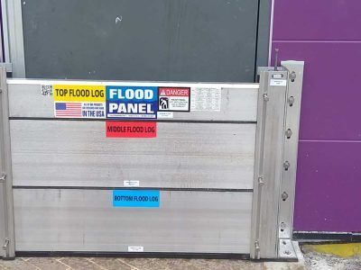 A flood panel is sitting in front of a purple door.