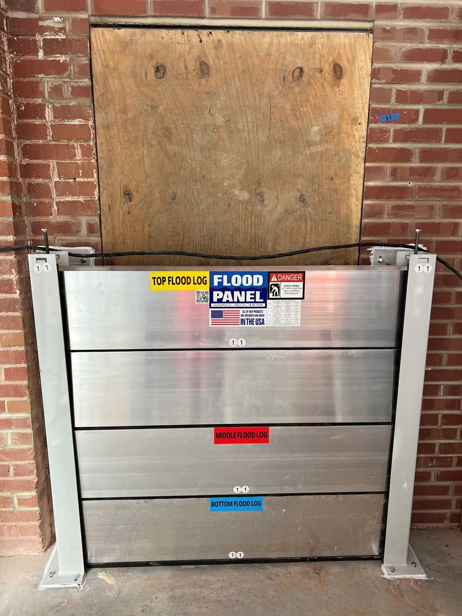 A flood panel is sitting in front of a brick wall.
