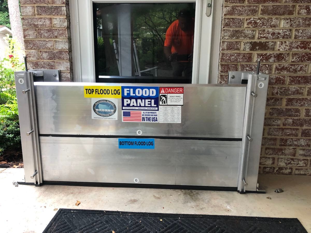 A flood panel is sitting in front of a brick building
