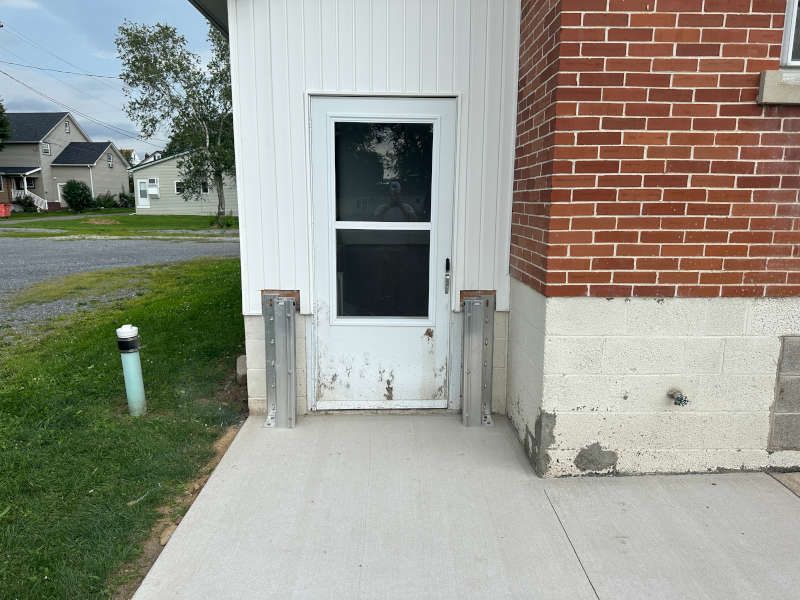 A brick building with a white door and a screen door