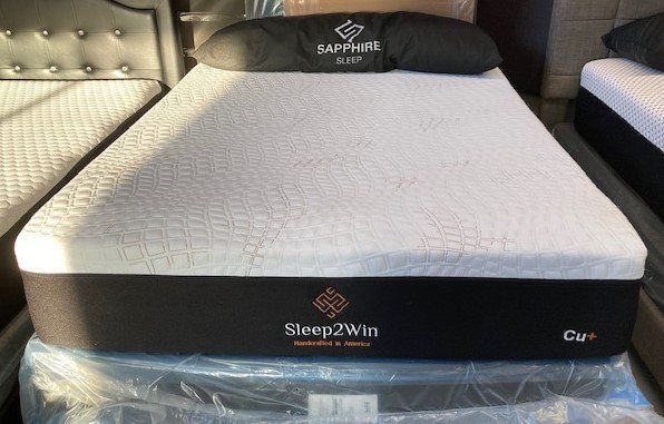 A sleep 2 win mattress is sitting on top of a bed.