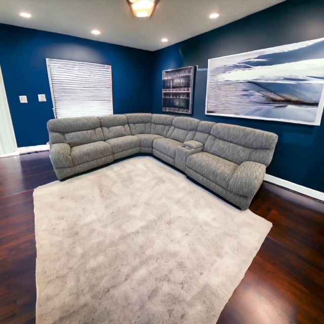 A living room with a sectional couch and a rug