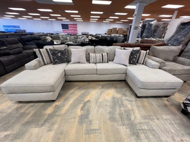 A sectional couch with a chaise lounge in a furniture store