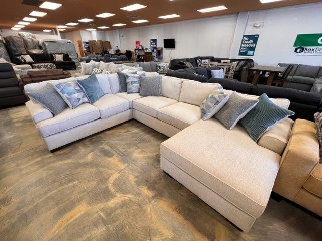A large sectional couch is sitting in a living room in a furniture store.
