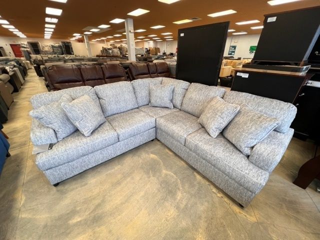 A large sectional couch is sitting in a furniture store.