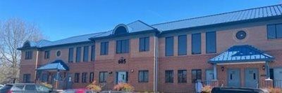 Brick school building with blue awnings and snowy grounds on a clear day