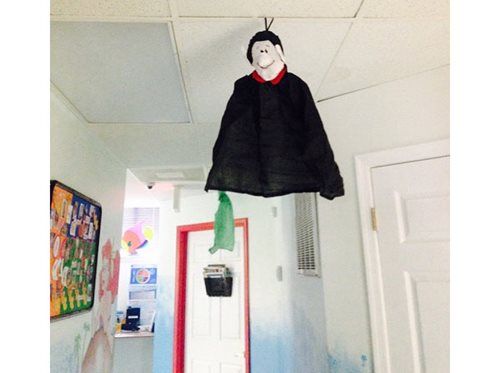 Hanging vampire decoration with black cape and red collar in a hallway doorway