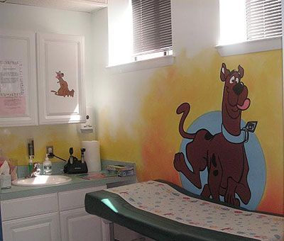 Scooby-Doo-themed bathroom with sink, mirror, and cartoon mural on the wall