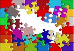 Colorful interlocking puzzle pieces scattered and fitting together on a white background