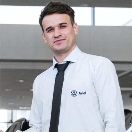 Um homem vestindo uma camisa branca e gravata preta com a palavra ariel escrita
