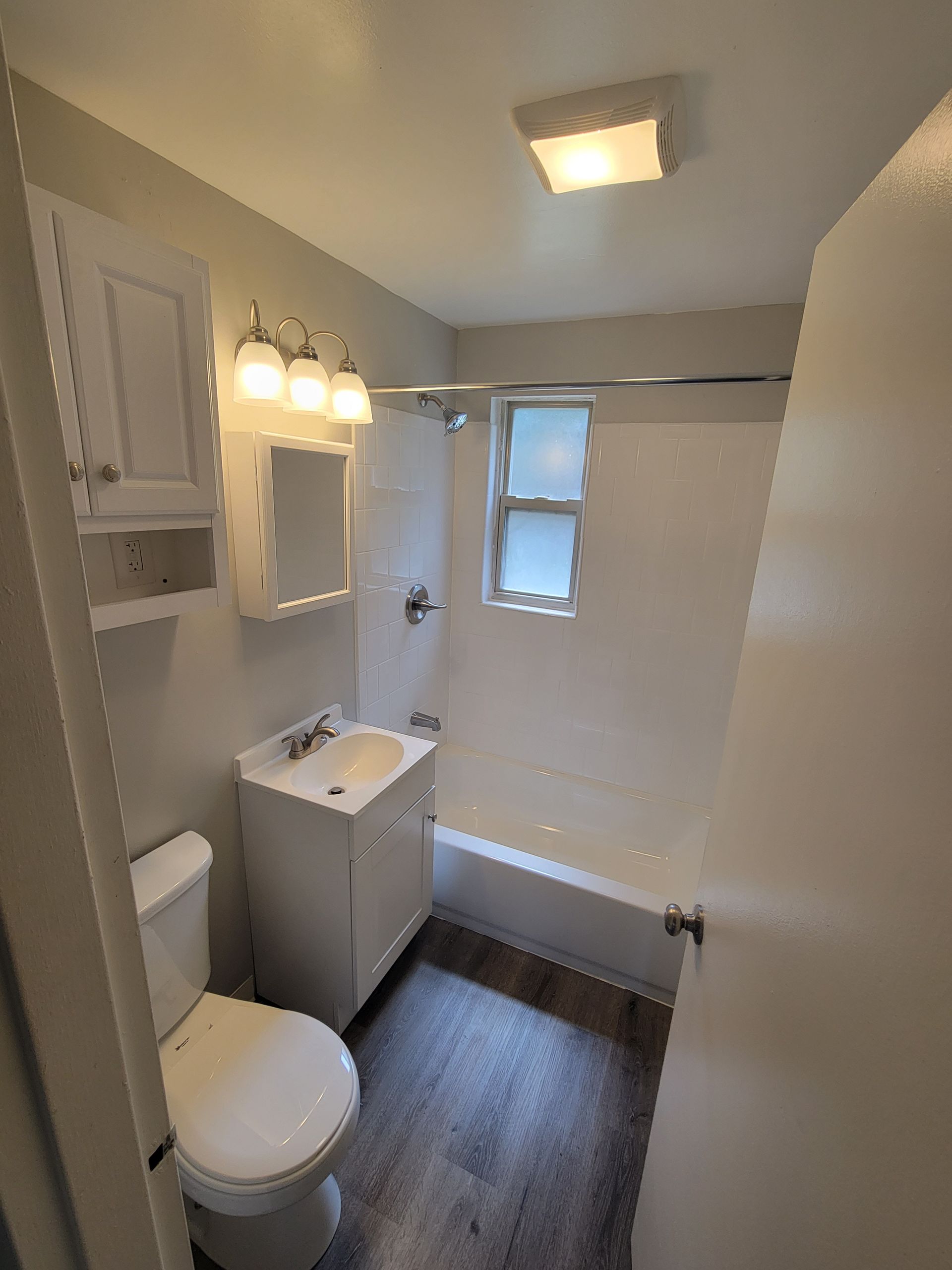 A bathroom with a toilet , sink , and bathtub.