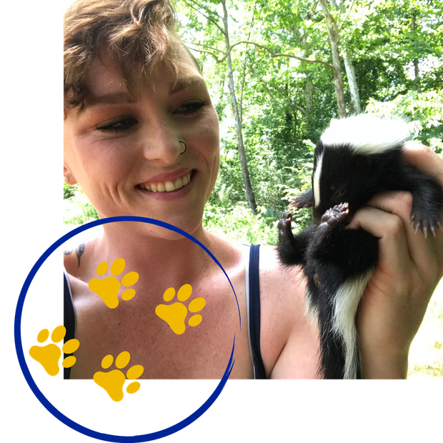 a woman is holding a small black and white animal in her hands
