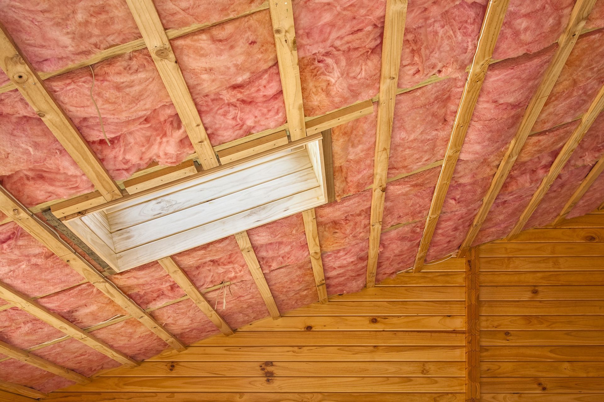 Exposed wood framing and spray foam insulation inside a house under construction