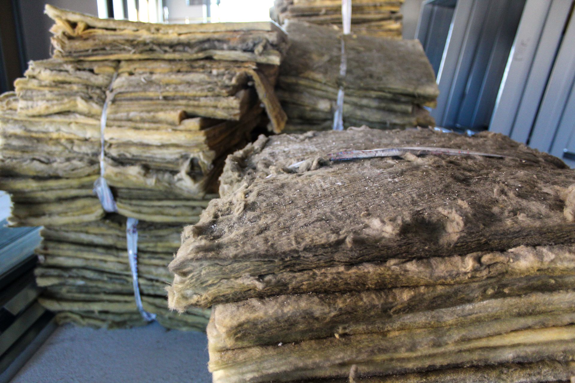 Bundled stacks of brown, dusty insulation.