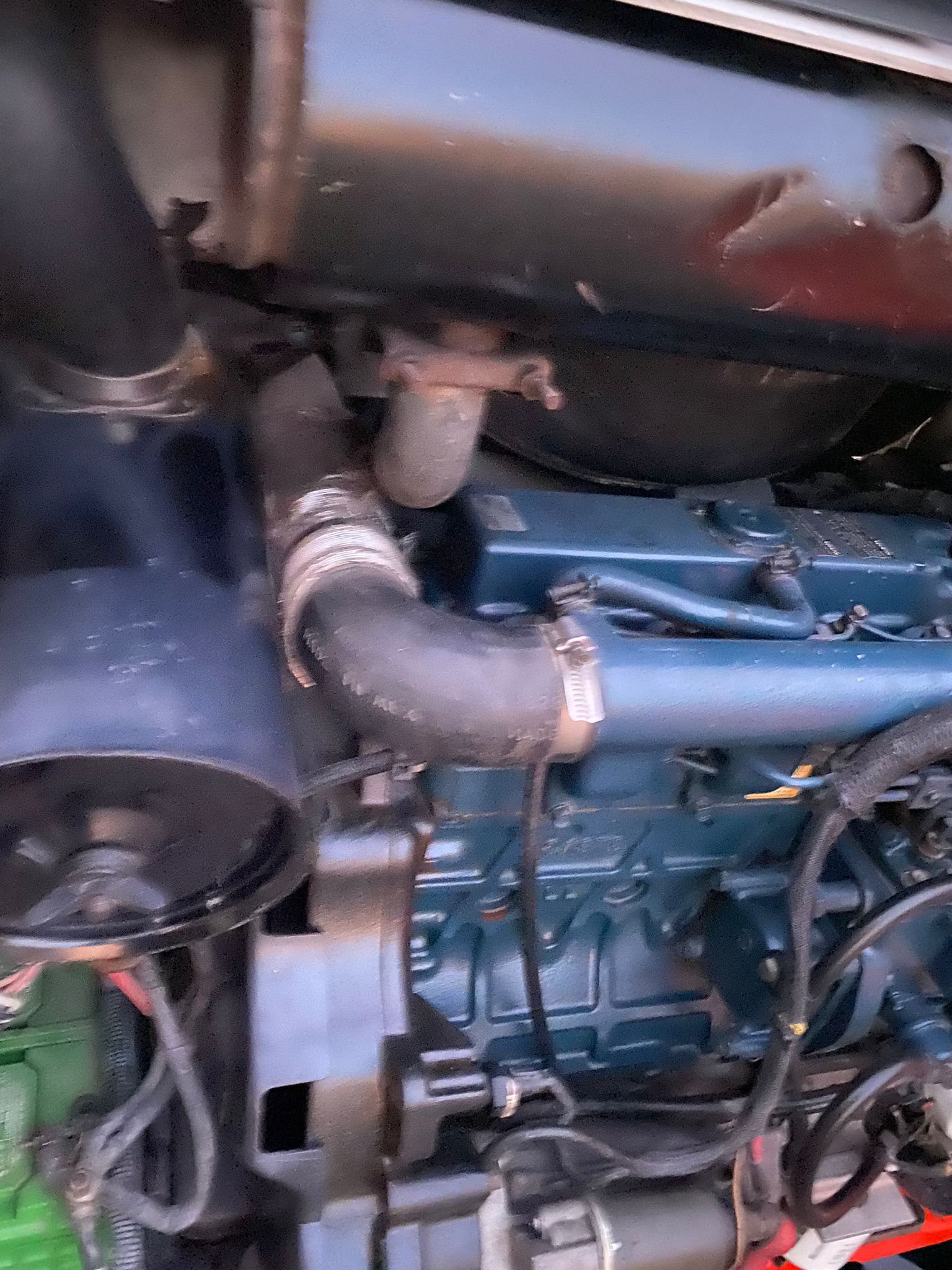 Black engine and components with a curved rubber hose and metal clamps, deliriomachinary