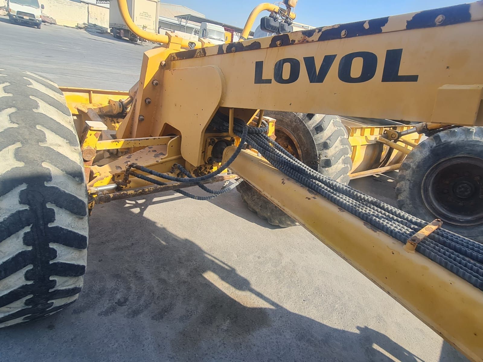 Yellow Lovol motor grader on a paved surface.