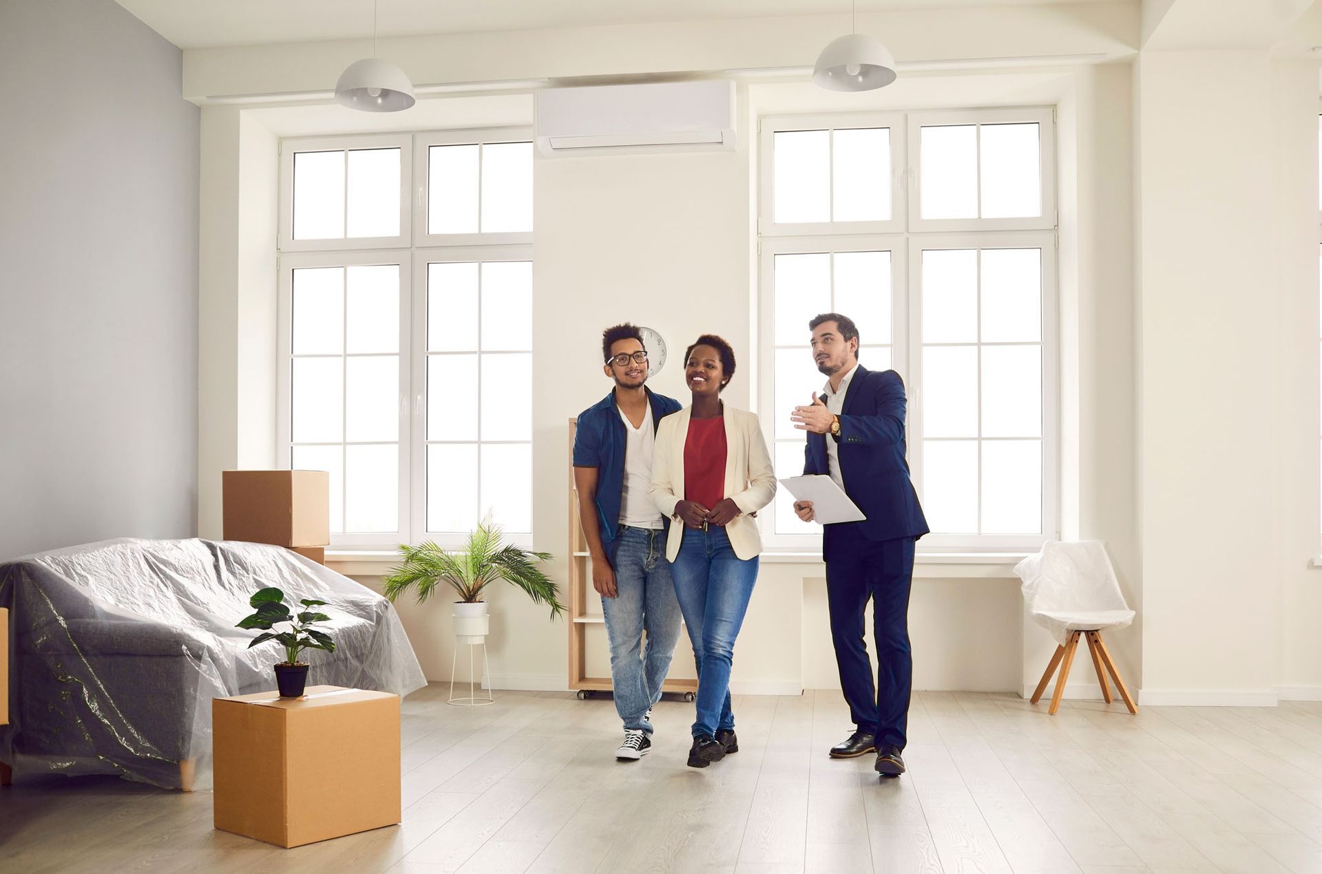 A man and a woman are looking at a house with a real estate agent.