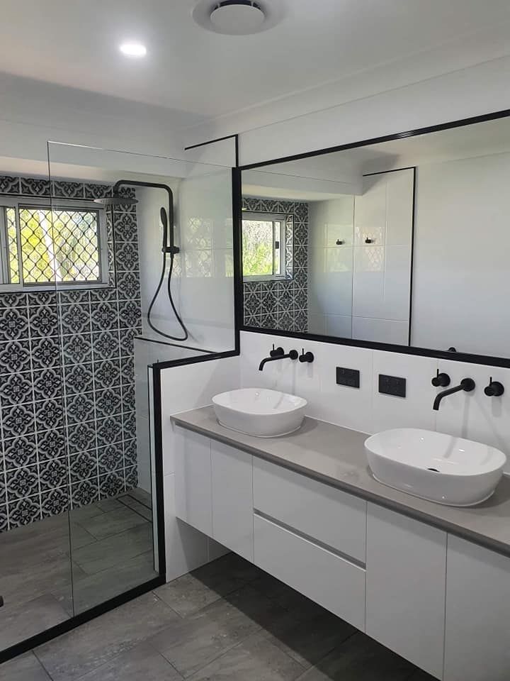 Bathroom With Elegant Mirror And Sink With Cabinets — Bathroom Renovations in Townsville, QLD