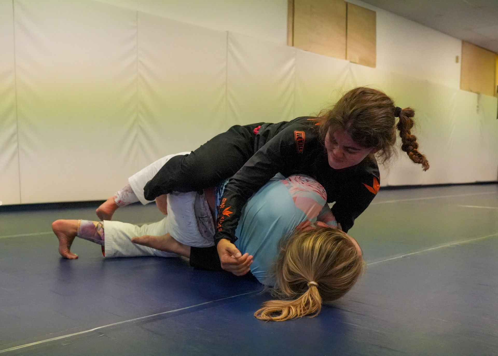 Teen girl practicing a guard pass during Brazilian Jiu Jitsu class in Oakley
