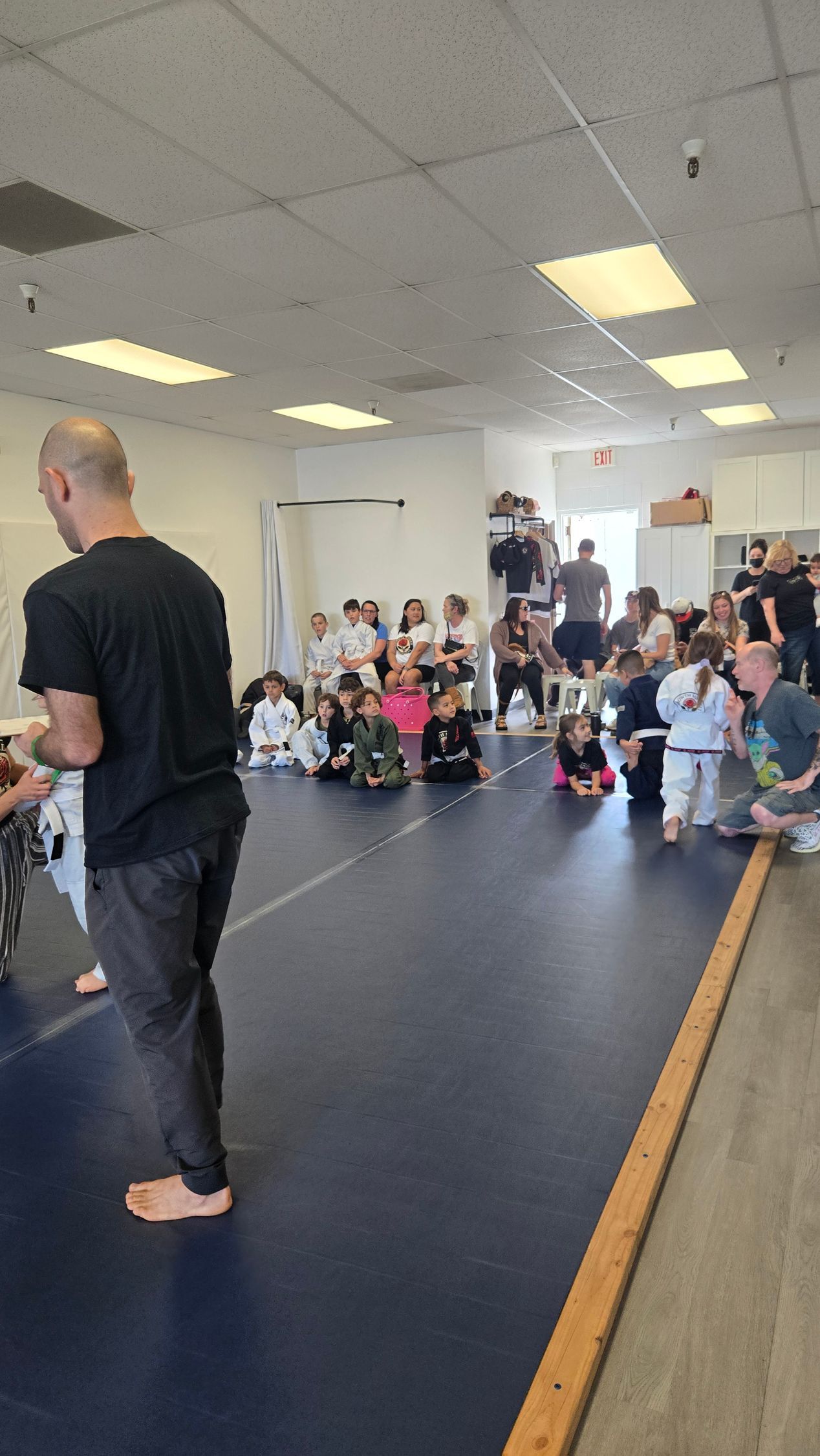 Classroom gathering with a speaker at front and a seated audience along the wall