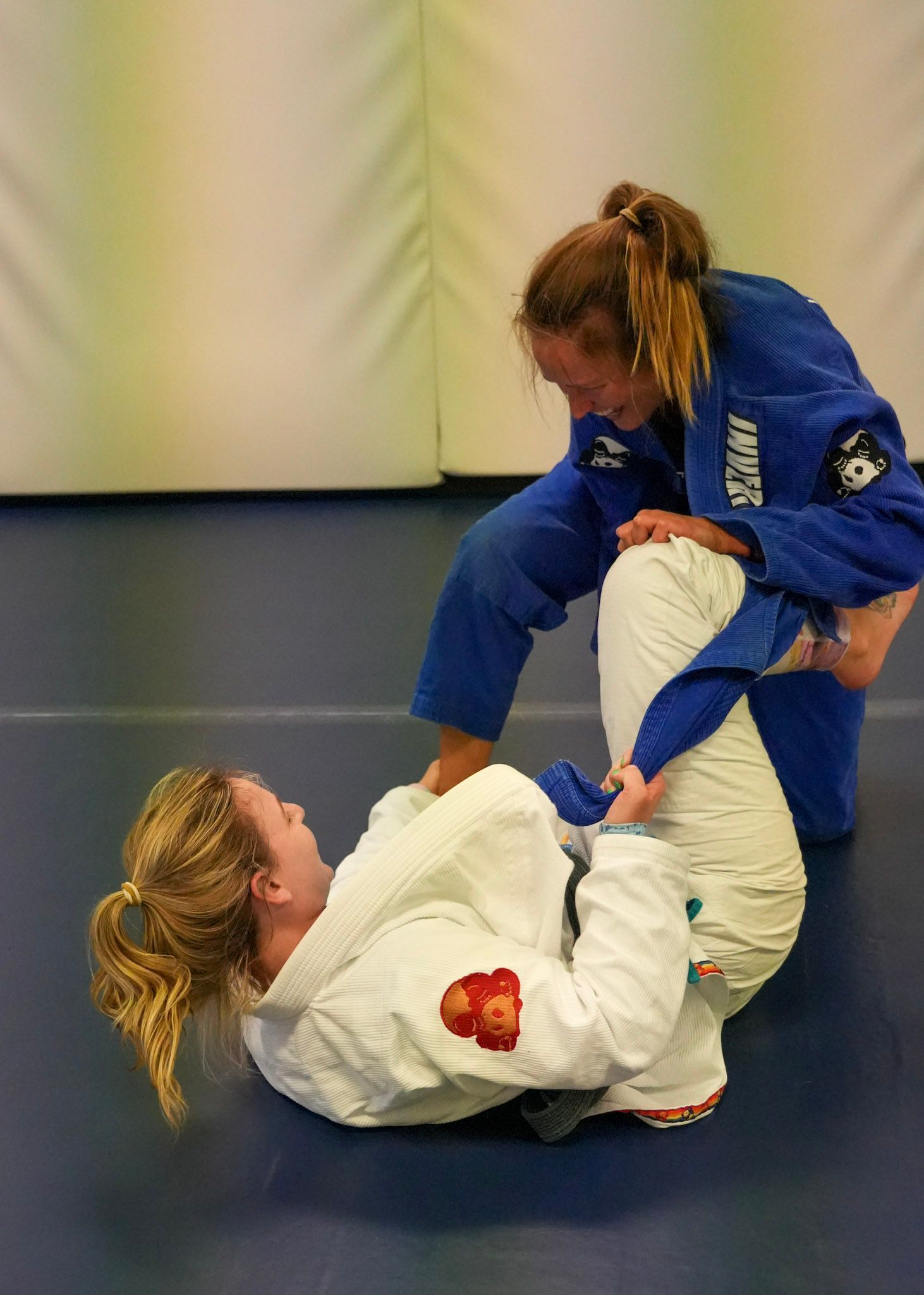Woman practicing guard retention during Brazilian Jiu Jitsu training