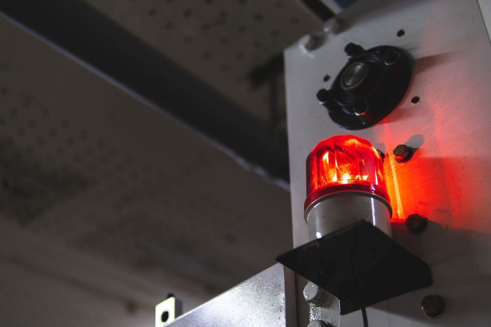 A Red Emergency Light Is Hanging From The Wall Of A Building — Fireline 2000 Fire Equipment Pty Ltd In Browns Plain, QLD