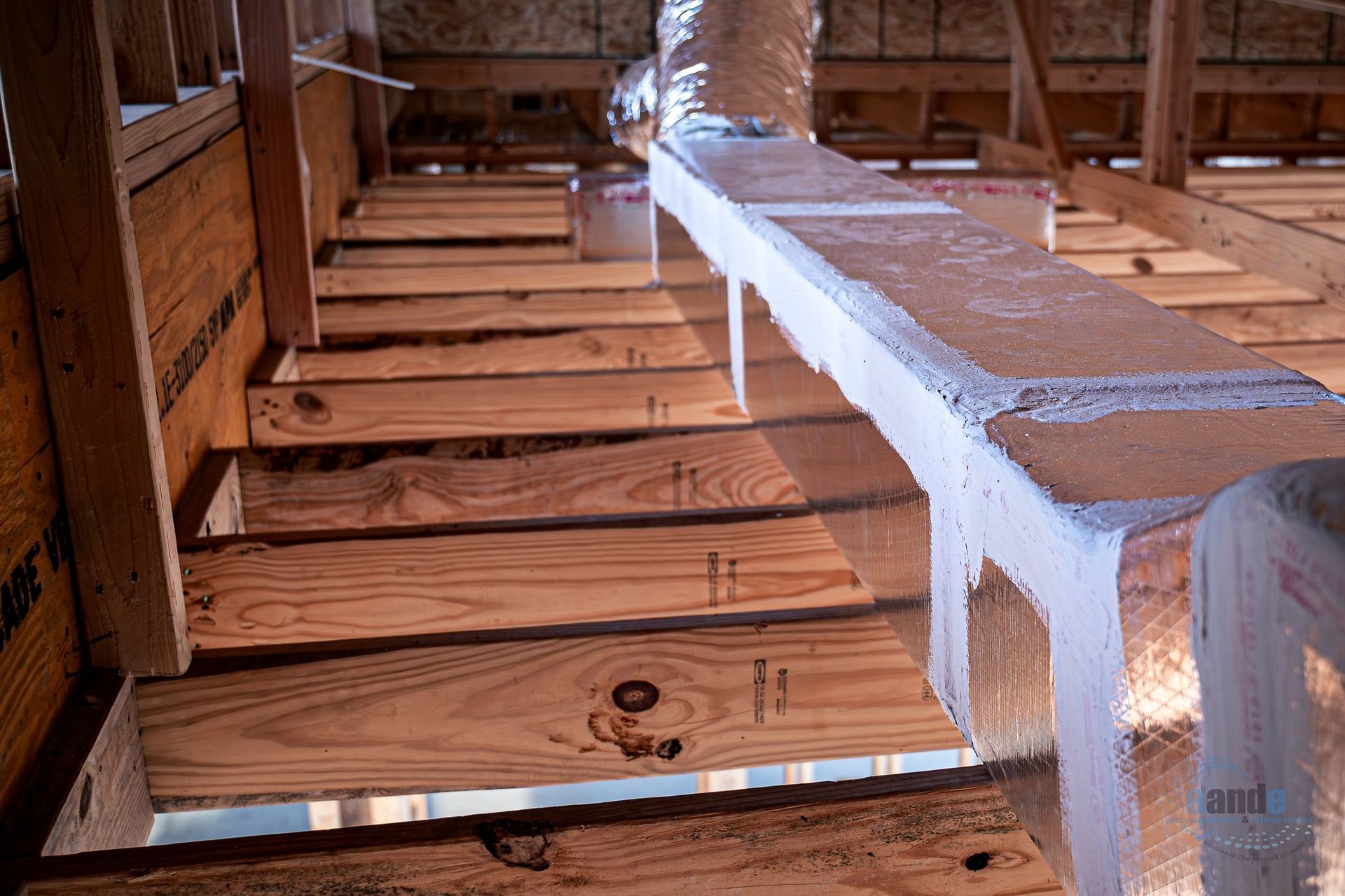 Wooden attic stairs under construction with a white painted banister and exposed framing