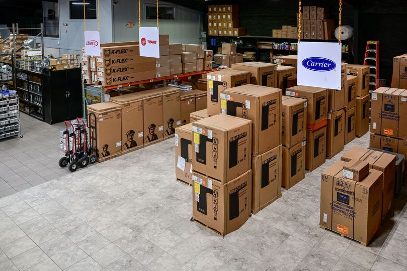 Warehouse filled with stacked cardboard boxes and pallets in an industrial storage area.