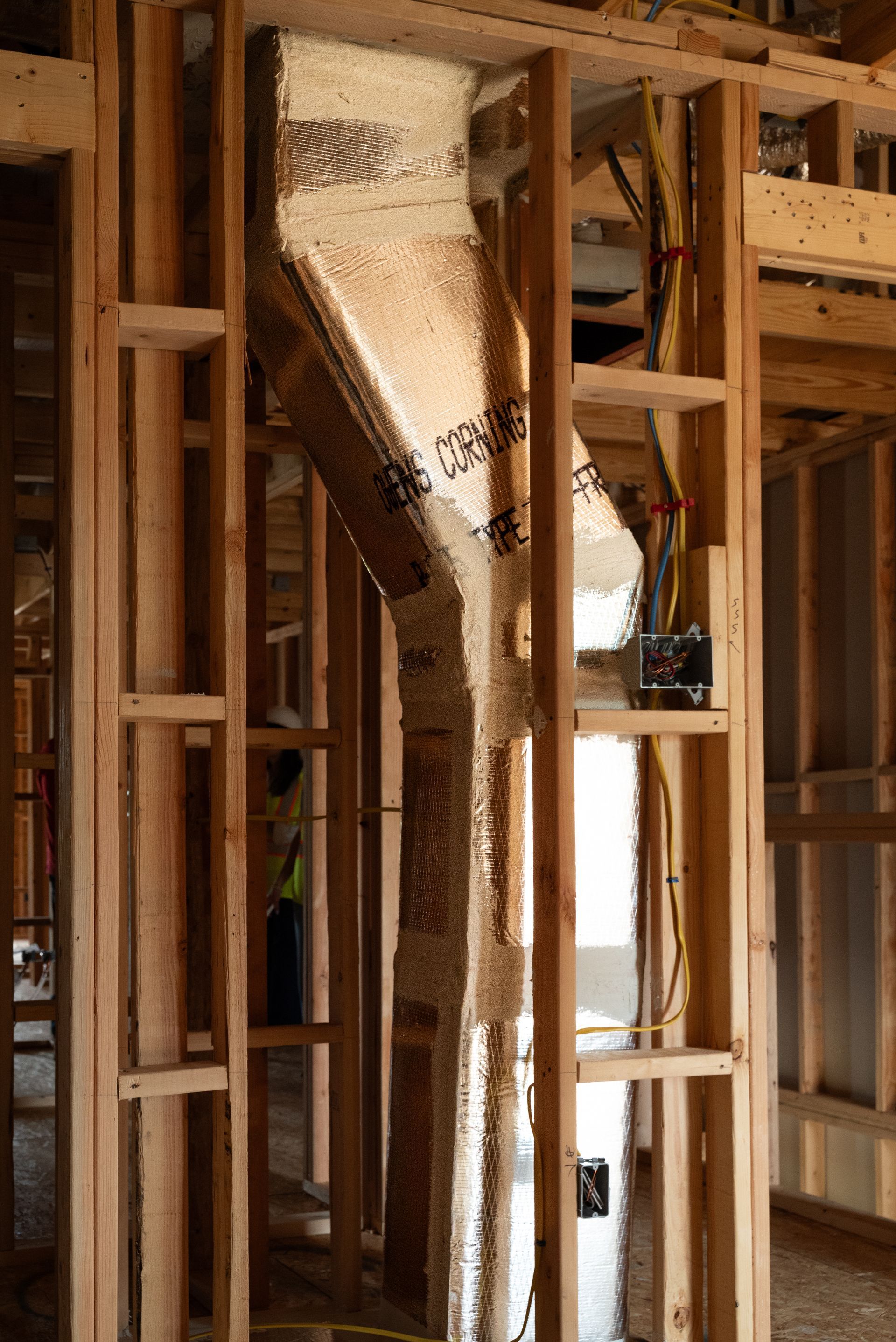 Interior wood framing with a vertical insulated duct or chute in a building under construction