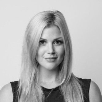 Portrait of a smiling blonde woman against a plain background