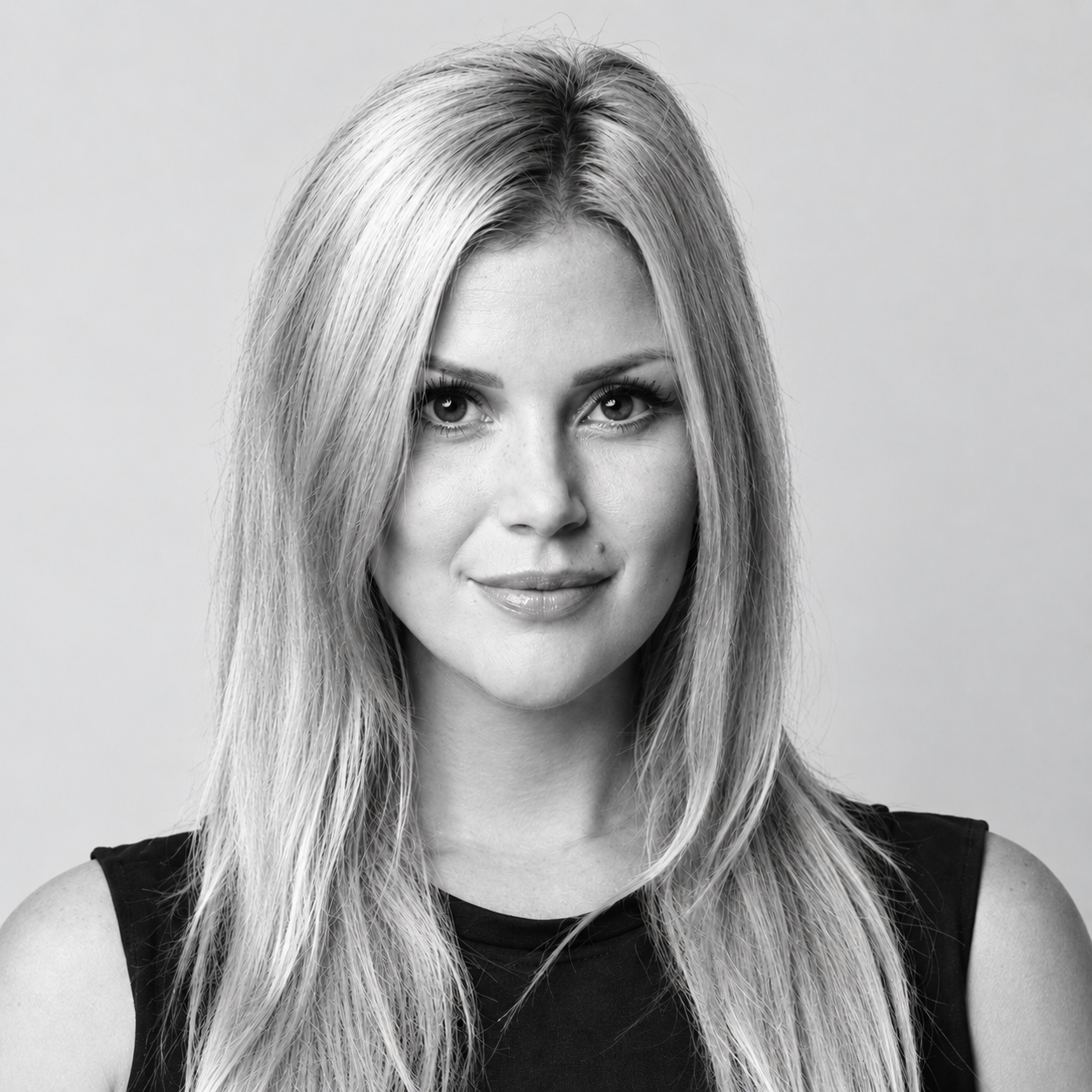 Portrait of a smiling blonde woman against a plain background