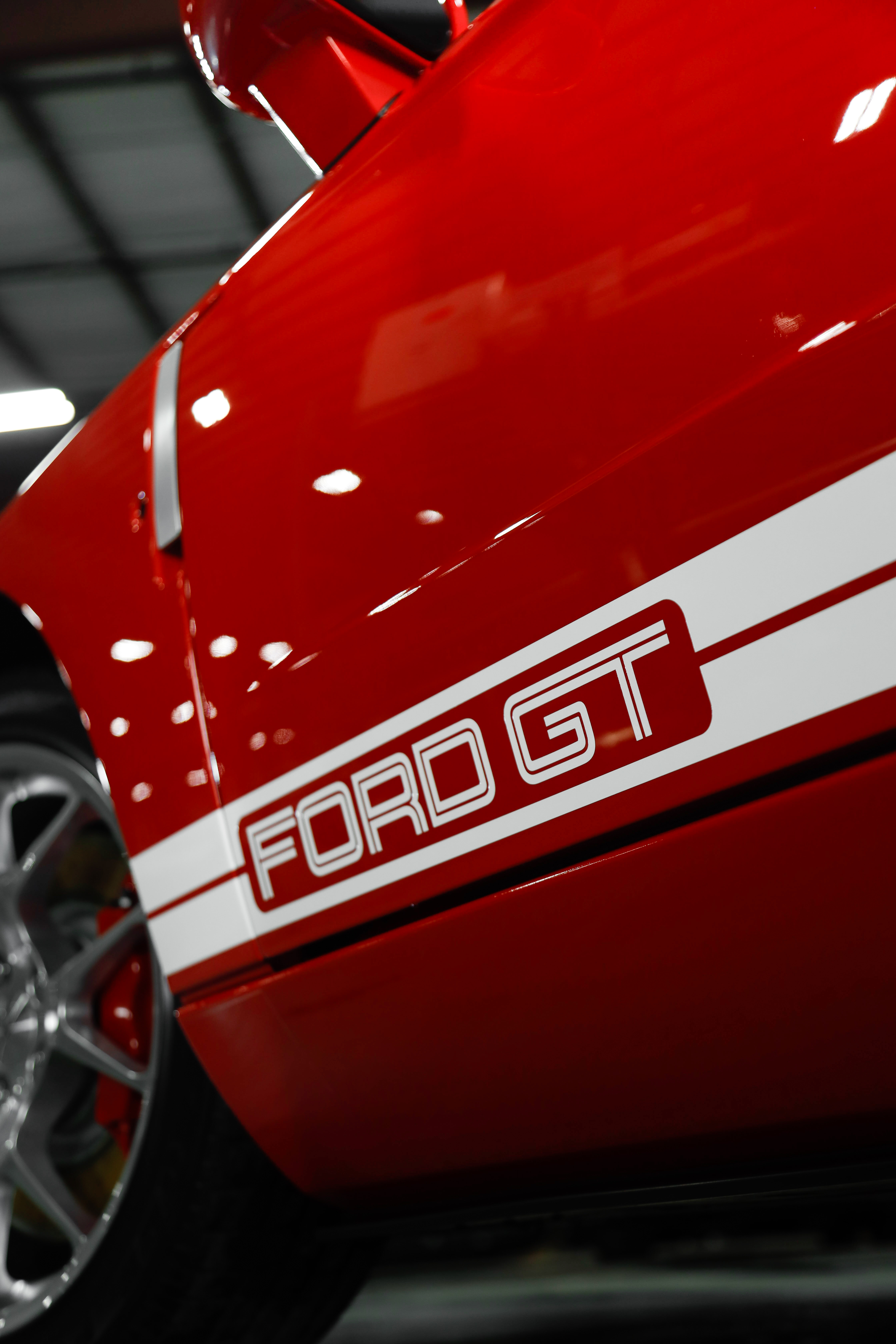 Red Ford GT car with white racing stripes and