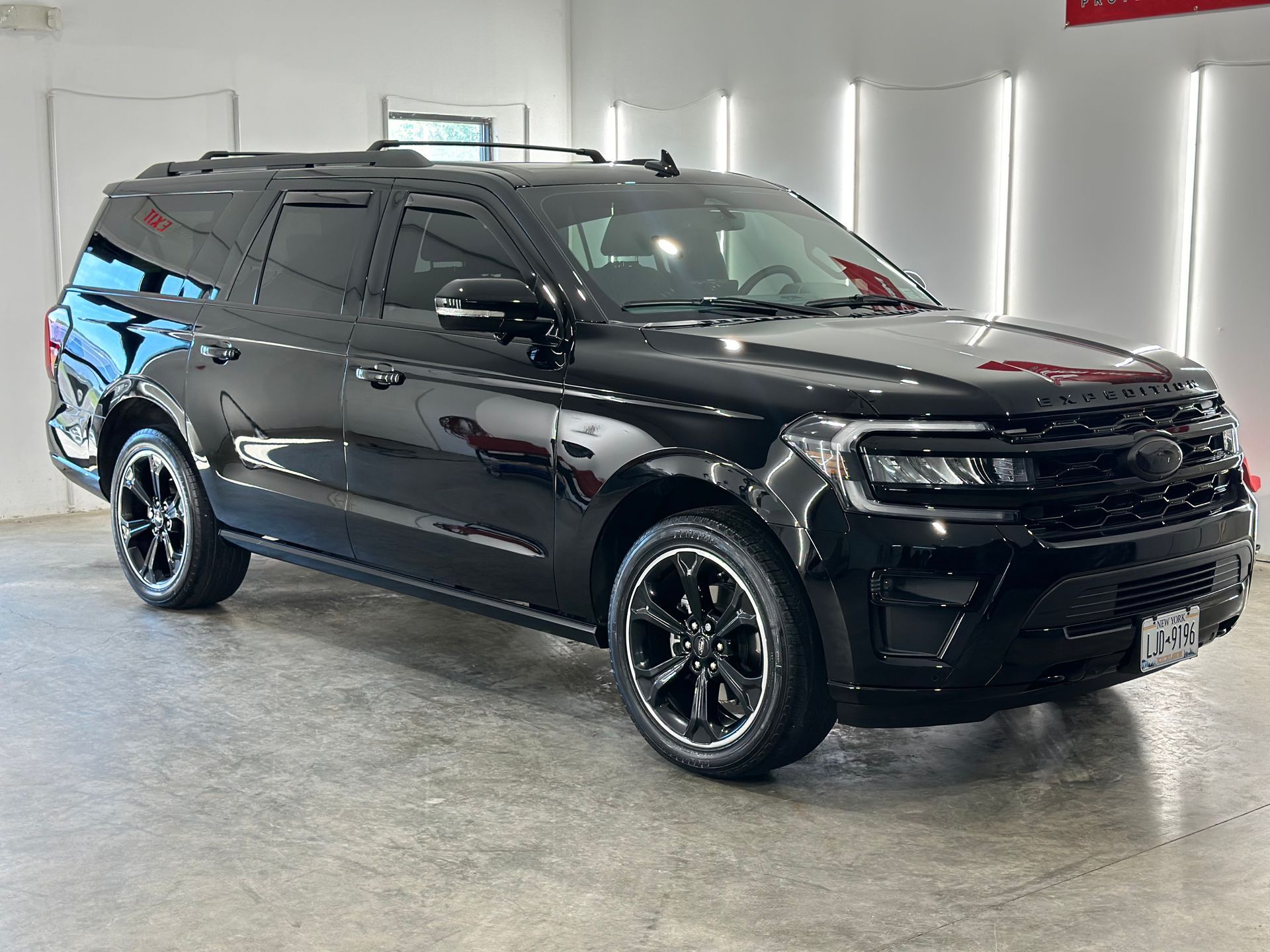 A black Ford Expedition SUV parked inside a brightly lit dealership showroom.