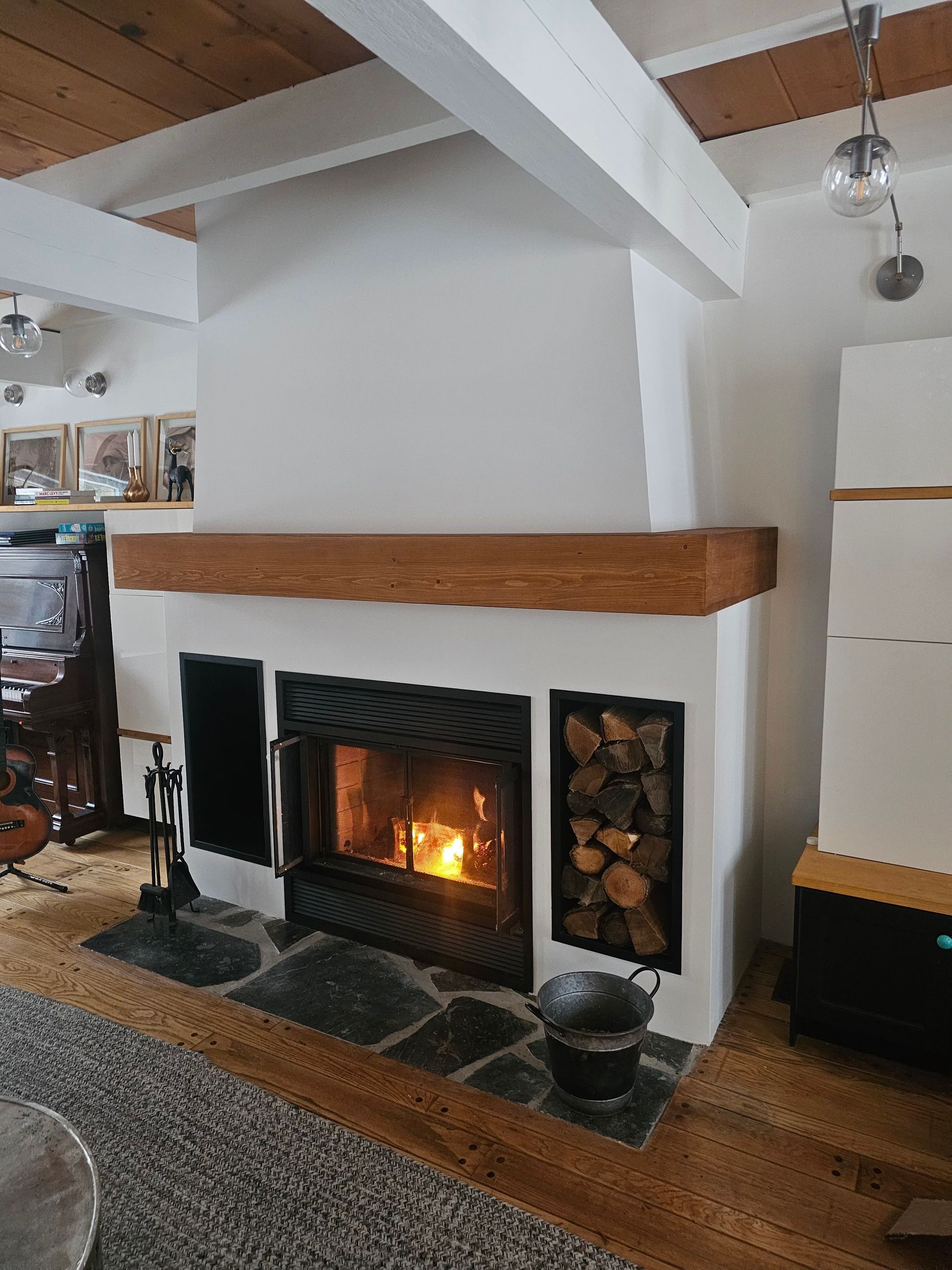 Un foyer dans un salon avec un manteau en bois