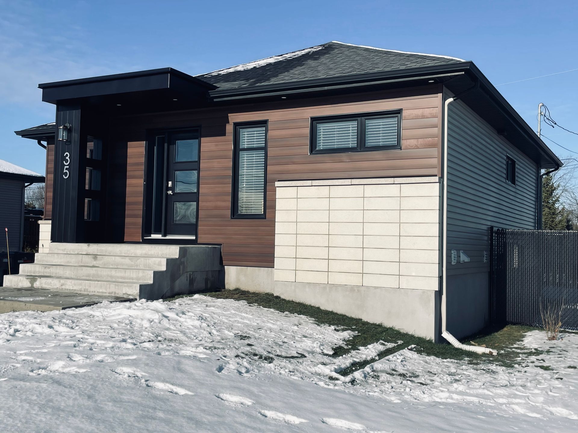 Une petite maison avec de la neige au sol devant