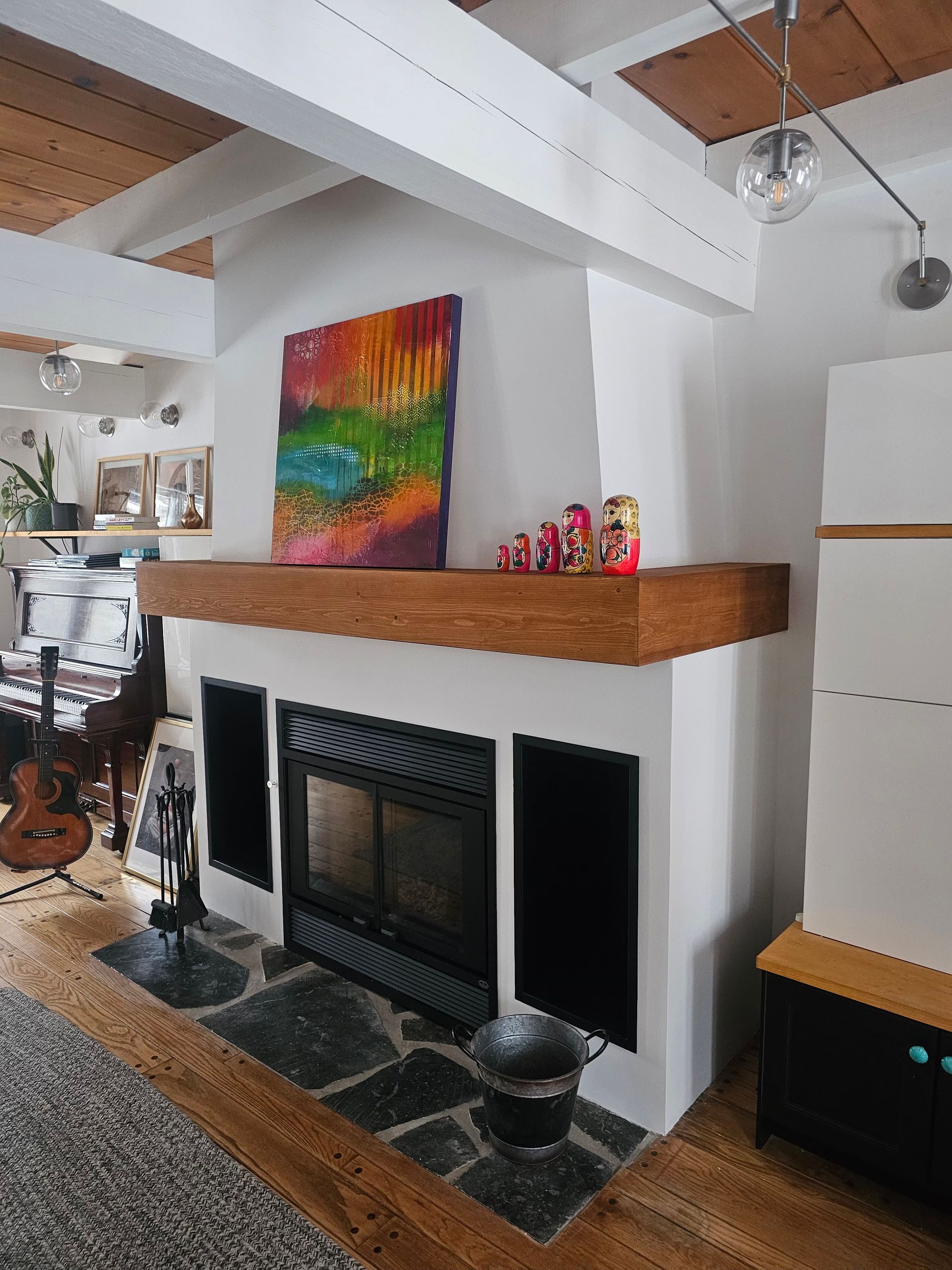 Un salon avec une cheminée et un tableau sur le manteau