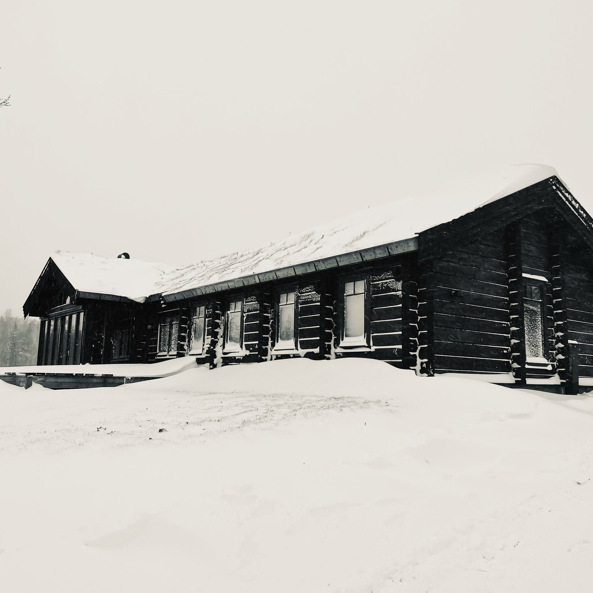 Snow-covered cabin in a winter landscape.