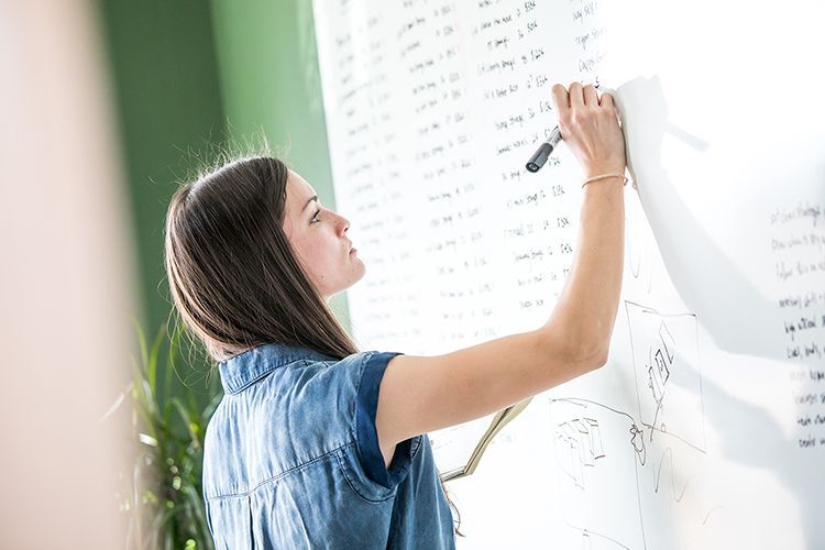 woman writing on whiteboard