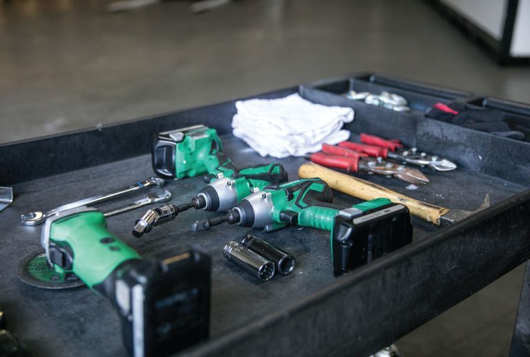 a tray of tools including a drills and wrenches