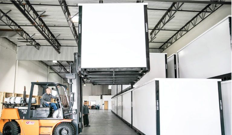 a man is driving a forklift in a large warehouse