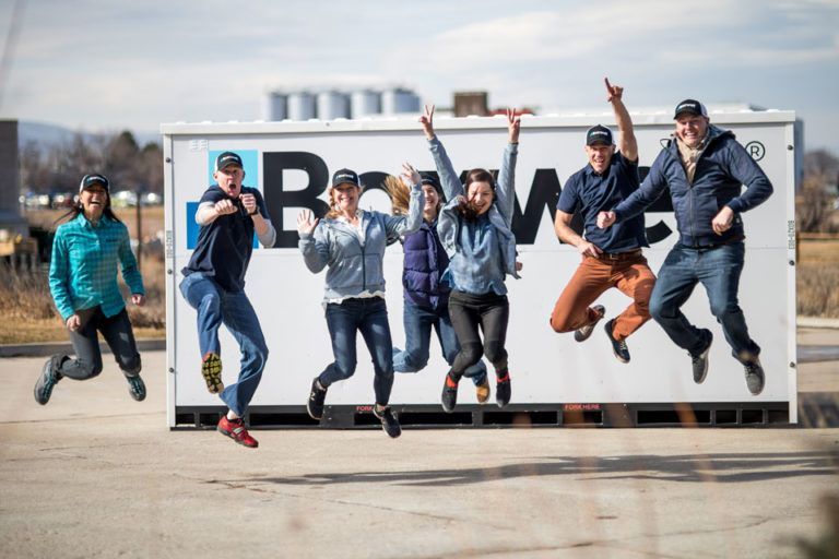 a group of people are jumping in the air in front of a storage unit