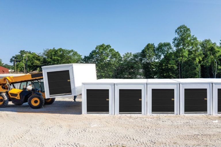 a man is loading a trailer into a row of storage units