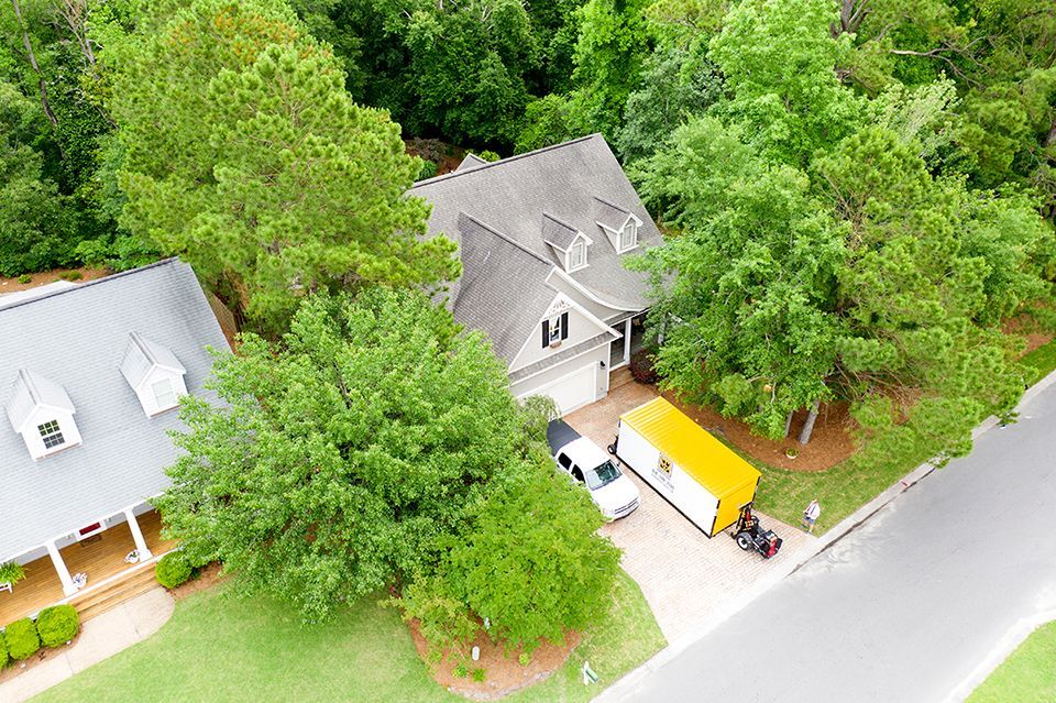 an aerial view of a house with a yellow van parked in front of it