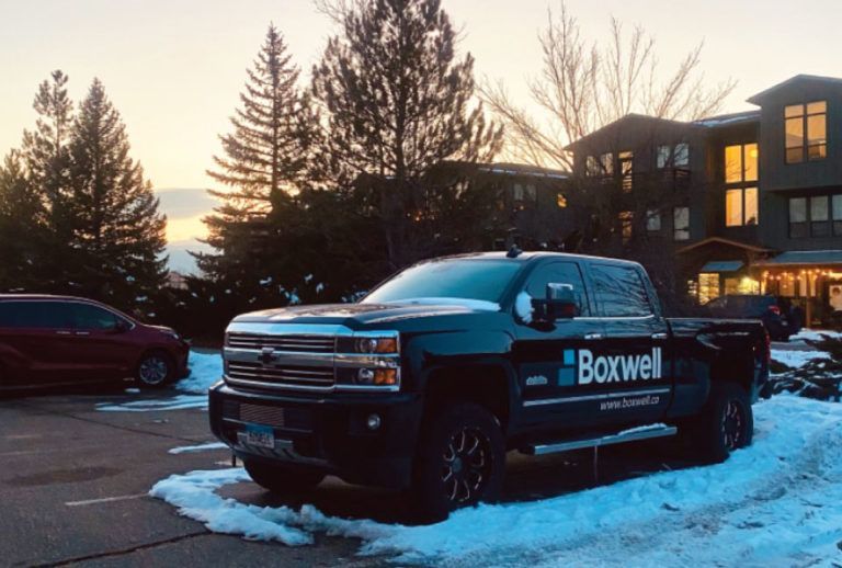 a boxwell truck is parked in a snowy parking lot