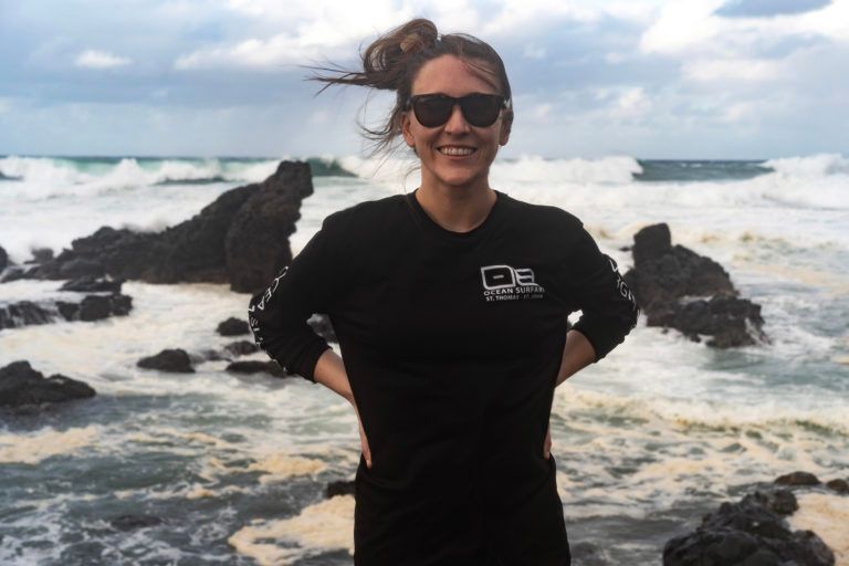 a woman wearing sunglasses and a black shirt that says ocean system on it