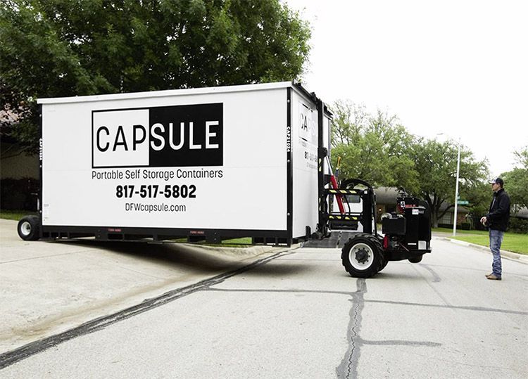 a capsule portable self storage container is being pulled by a forklift