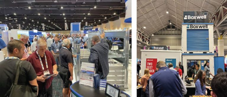 a group of people are standing around a booth at a convention .